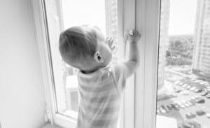 Child in danger of falling out of window because there are no window guards
